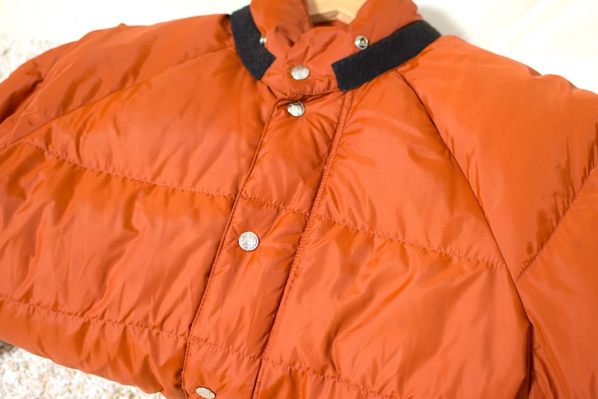 オレンジ色のREIのダウンジャケット